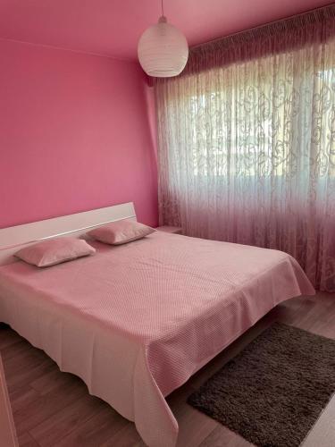 - une chambre rose avec un lit et une fenêtre dans l'établissement Schirmeck Apartment, à Strasbourg