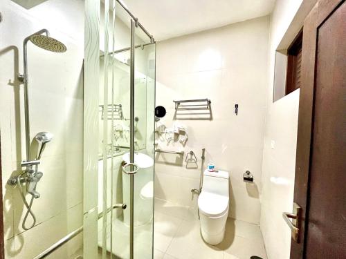 a bathroom with a glass shower and a toilet at Hotel Randiya Anuradhapura in Anuradhapura