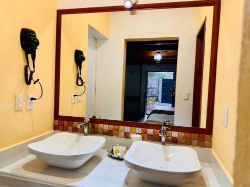 baño con 2 lavabos y espejo grande en Hotel Hacienda Real en Querétaro