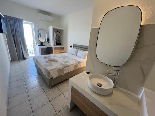 a bedroom with a bed and a mirror on the wall at Koukounari Agistri in Skala