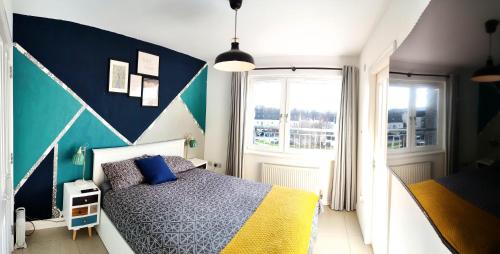 Un dormitorio con una cama con una pared de acento azul en La Casita, Your Home Away from Home - Free Parking, en Glasgow