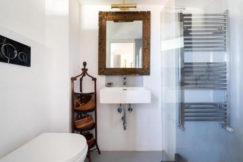 a bathroom with a white toilet and a mirror at Farnese Stunning Penthouse | Romeloft in Rome