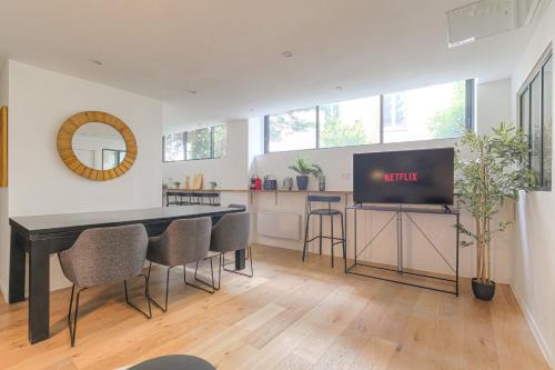 Il comprend un salon doté d'une table à manger et d'une télévision. dans l'établissement Cosy et Calme idéal déplacement pro, à Lyon