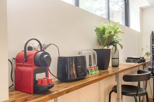 un comptoir avec une valise rouge posée dessus dans l'établissement Cosy et Calme idéal déplacement pro, à Lyon