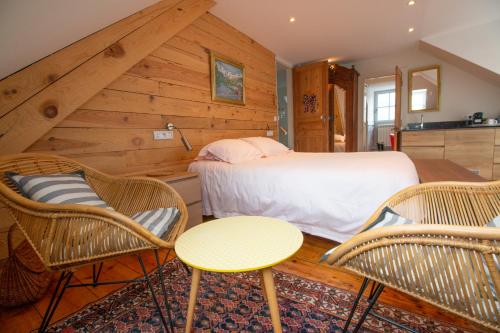 a bedroom with a bed and two chairs and a table at LE 41 AVENUE FOCH in Luchon
