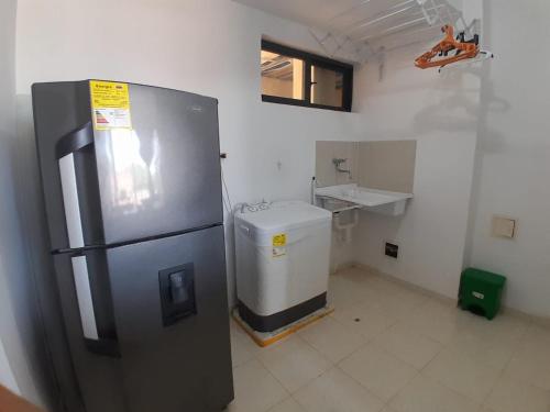 a kitchen with a stainless steel refrigerator and a sink at Portal de la Sierra Apto 207 in Playa Dormida