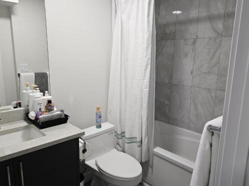 a white bathroom with a toilet and a shower at Feel At Home in Edmonton