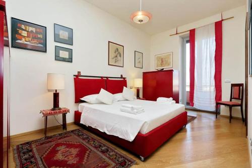 una camera con un grande letto con testiera rossa di Saint Peter's Bright Apartment | Romeloft a Roma