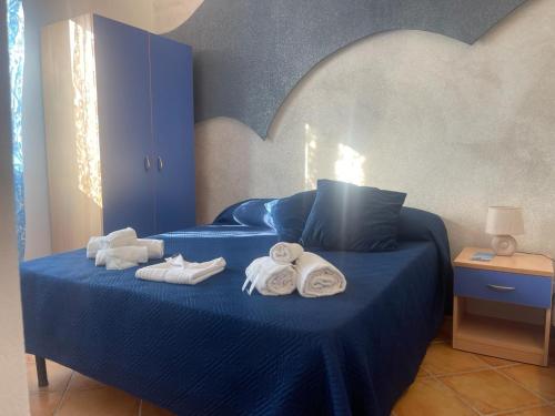 a bedroom with a blue bed with towels on it at "L'Oasi di Favignana" Room and Charme in Favignana