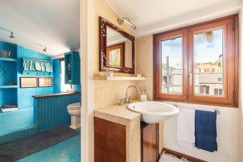 a bathroom with a sink and a toilet and a mirror at Piazza Mattei Terrace Apartment | Romeloft in Rome