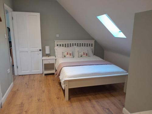 a bedroom with a white bed with a skylight at Egypt Granary in Tonbridge