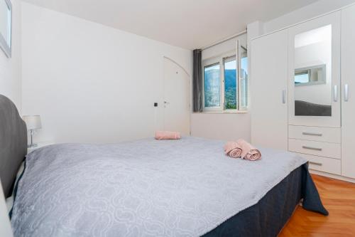 Un dormitorio con una cama con toallas rosas. en Dani, en Omiš