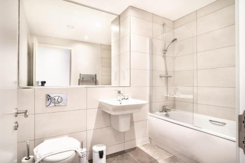 y baño con aseo, lavabo y ducha. en Modern 3 Bedroom Manchester Apartment, en Mánchester