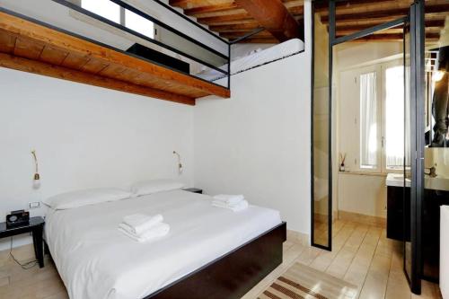a bedroom with a large white bed and a window at Pantheon Stylish Attic in Rome