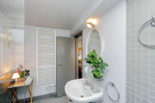 La salle de bains est pourvue d'un lavabo blanc et d'un miroir. dans l'établissement Scala Luxury Terrace studio, à Rome