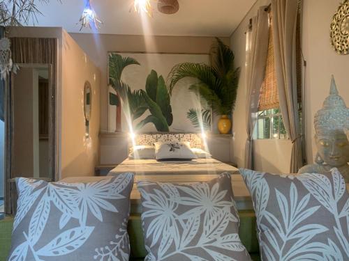 Palms Ocean views في Rodrigues Island: غرفة نوم مع سرير ووسائد زرقاء وبيضاء