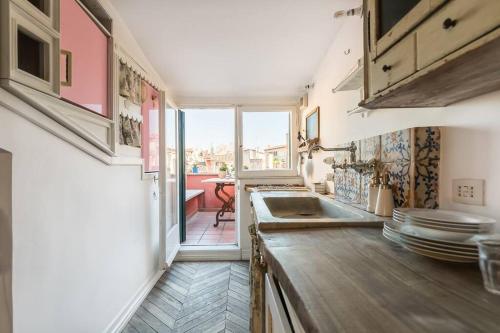 a kitchen with a sink and a counter with plates at Scala Lovely Terrace Apartment in Rome