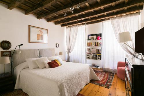 een slaapkamer met een wit bed en een raam bij Farnese Charming Apartment in Rome