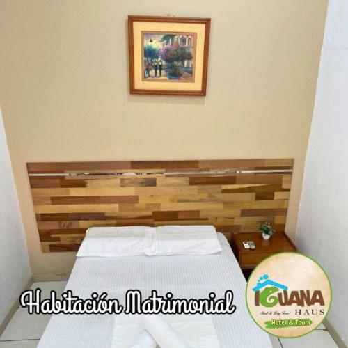 a bedroom with a bed and a picture on the wall at IGUANA HAUS IQUITOS in Iquitos