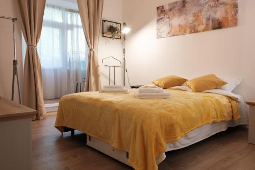 - une chambre dotée d'un grand lit avec des draps jaunes dans l'établissement Konstanzer Tudor3, à Iaşi