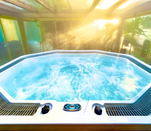 a jacuzzi tub with the sun shining in it at Alaçatı Wellness Garden in Alacati
