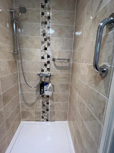 y baño con ducha de azulejos. en Private Apartment in Windsor, en Windsor