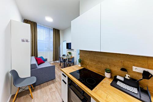 a kitchen with a stove and a couch in a room at Kora Apartments Andel in Prague
