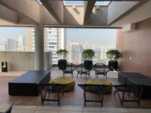 Habitación con mesas, sillas y vistas a la ciudad. en SP Stays Emotion - Brooklin, en São Paulo