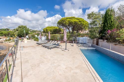 une piscine avec des chaises et des parasols à côté d'une clôture dans l'établissement Toowoomba Boathouse, à La Garonnette-Plage