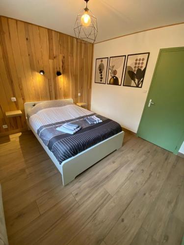 1 dormitorio con 1 cama en una habitación con paredes de madera en Petit cocon comme a la maison, en Villard-de-Lans