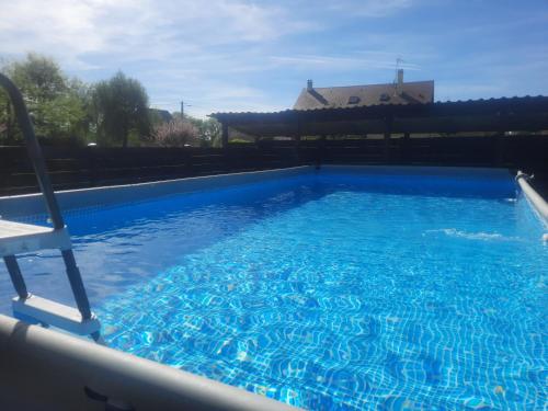 a large blue swimming pool with a chair in it at GITE CHEZ MONETTE in Nance