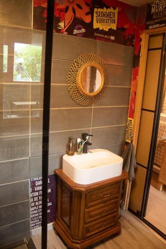 une salle de bain avec un lavabo et un miroir dans l'établissement LE COCON, à Scherwiller