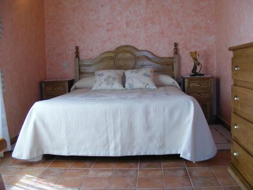 a bedroom with a bed with a white bedspread at Hotel Rural El Museo in Cedillo de la Torre