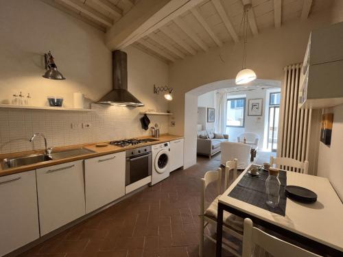 uma cozinha com armários brancos e uma mesa com um lavatório em Your Terrace in Fiesole em Fiesole