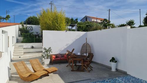 um pátio com uma mesa, cadeiras e uma cerca em Villa piscine balnéothérapie entièrement privée em Barras