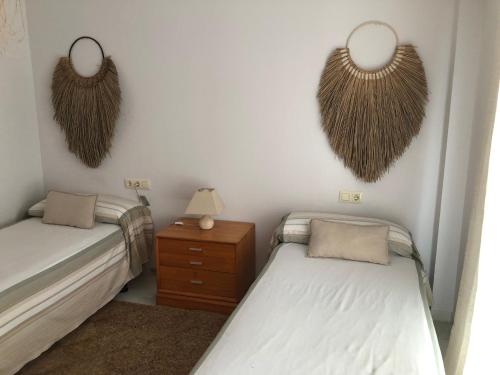 2 Betten in einem Zimmer mit Hörnern an der Wand in der Unterkunft Casa De La Luz in Tarifa