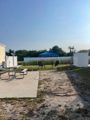 a park with two benches and a blue umbrella at RV SITE FOR RENT BY GLAMPERS CAMP 30AMP FULL HOOKUP in Port Charlotte