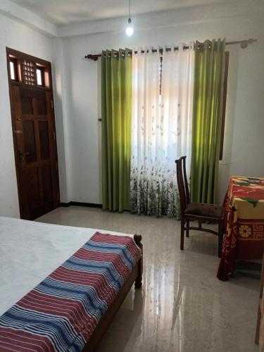1 dormitorio con 1 cama, 1 silla y 1 ventana en White's villa, en Matara