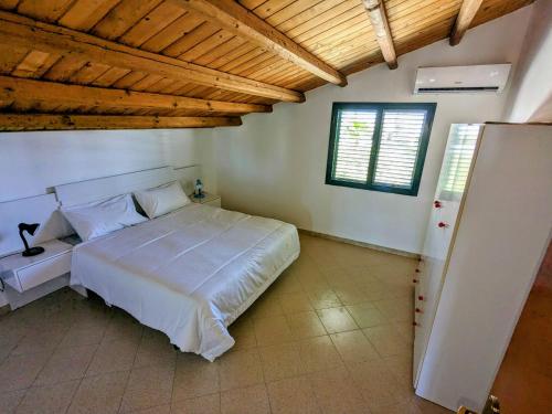 ein Schlafzimmer mit einem großen weißen Bett und einem Fenster in der Unterkunft Margus in Punta Braccetto