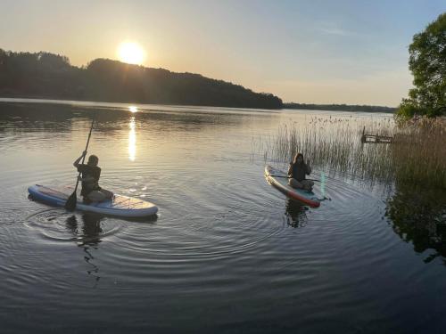 two people are sitting on kayaks in the water at Dom wczasowy Rychertówka in Grzebieniec