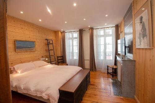 a bedroom with a large bed in a room with wooden walls at LE 41 AVENUE FOCH in Luchon