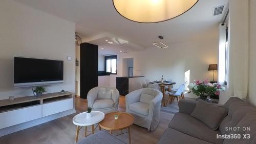 sala de estar con sofá y TV de pantalla plana en Notre Vie Là, villa 3 chambres, piscine, climatisation, vue sur les Albères, en Sorède