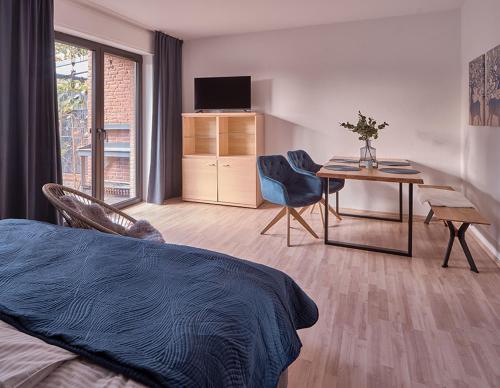 a bedroom with a bed and a desk and a table at KATARINAS HOUSE mit 2 FeWo stilvoll, gemütlich & zentral Boxspringbett, Parkplatz, Balkon oder Garten in Moers