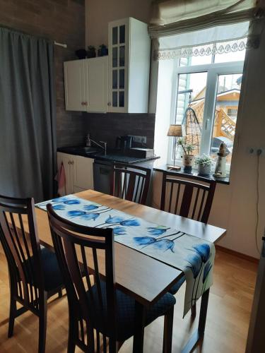 a kitchen with a wooden table with chairs and a dining room at Vintage Four in Haapsalu