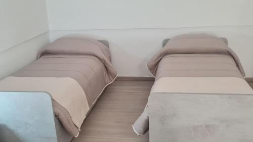 two beds sitting in a room with ainylinylinylinylinyl at CASA VACANZA PARADISO in Manfredonia