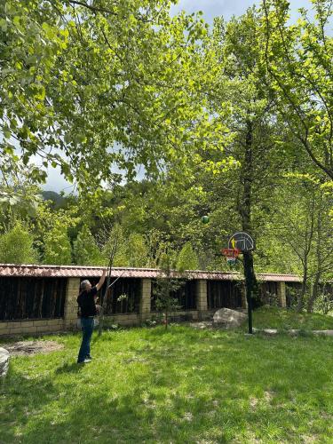 a person standing under a tree playing with a frisbee at Istisu Valley Spa in İsmayıllı