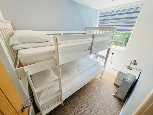a bedroom with two bunk beds and a window at 2 Bedroom Chalet SB57, Sandown, Isle of Wight in Brading