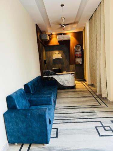 a living room with a blue couch and a table at Royal Palace Lucknow in Lucknow