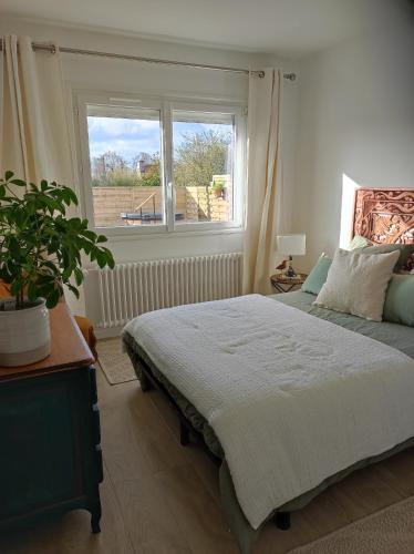 a bedroom with a large bed and a window at La Sapinière in Perros-Guirec