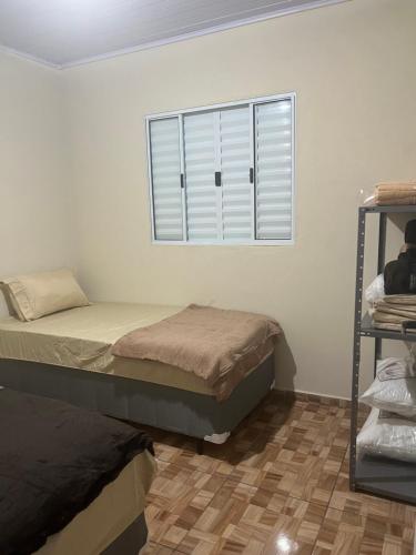 sypialnia z 2 łóżkami i oknem w obiekcie Casa do Monte w mieście Guarulhos